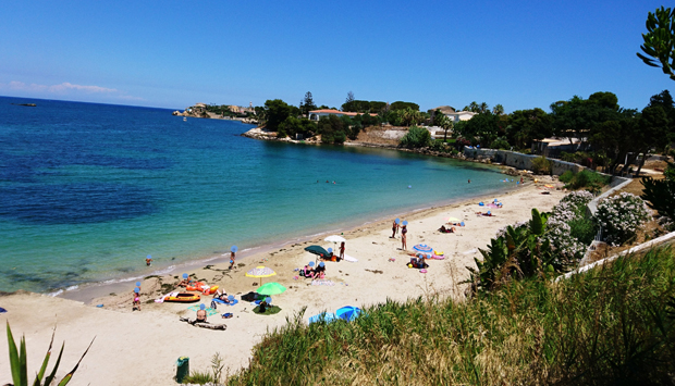 La spiaggia Punta del Pero, di fronte al magnifico skyline di Siracusa